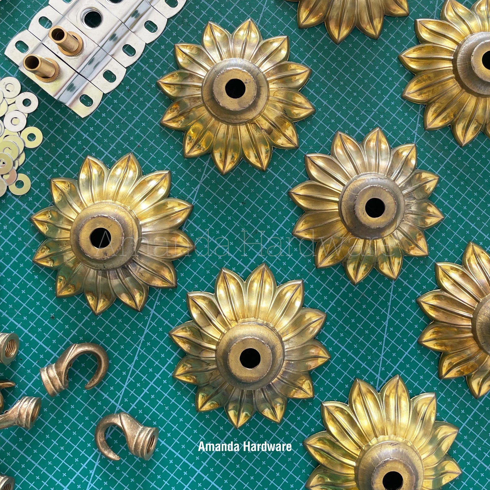 Flower petal brass hook assembly on green mat.