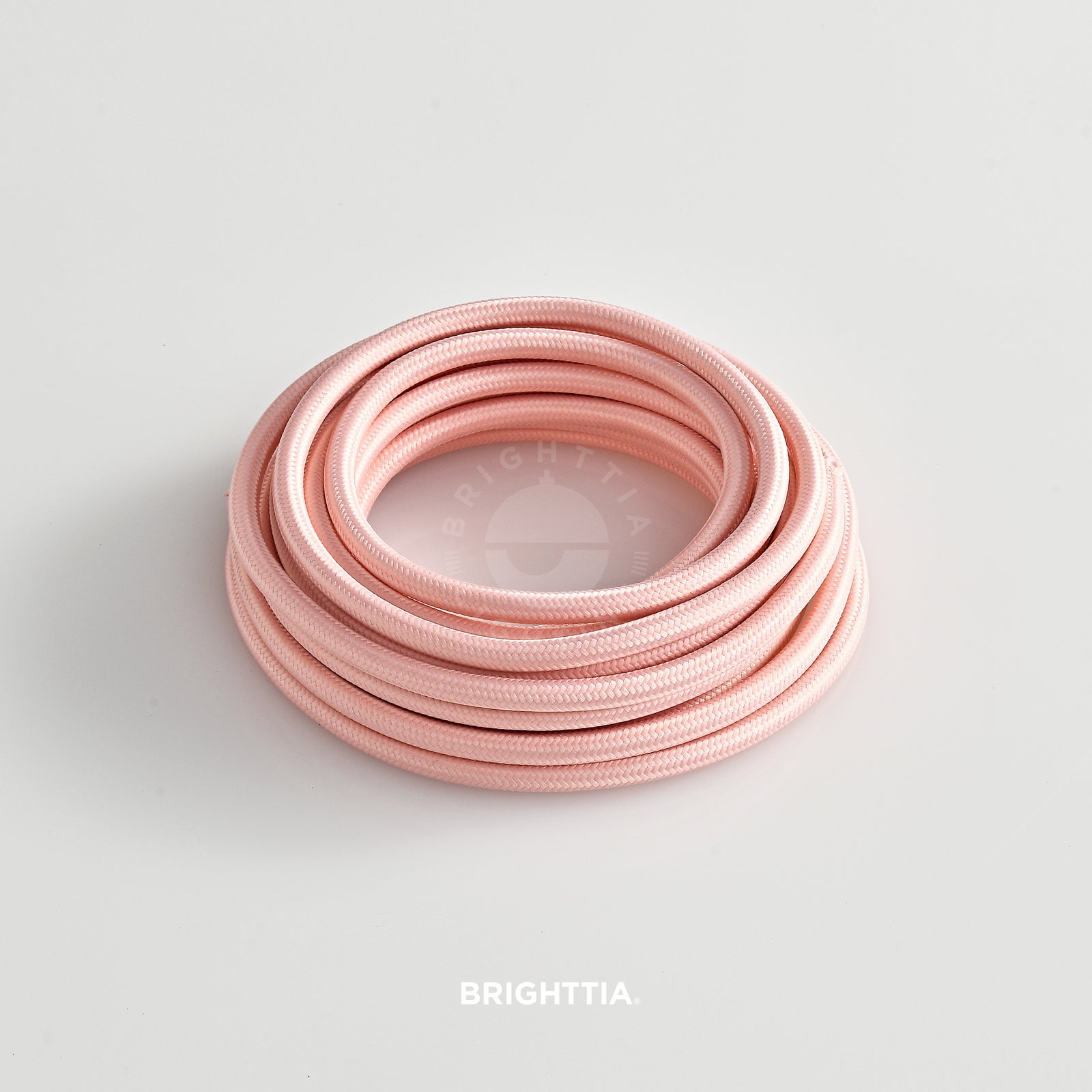 A roll of solid round light pink fabric cord 4.88m (16ft) on a white background
