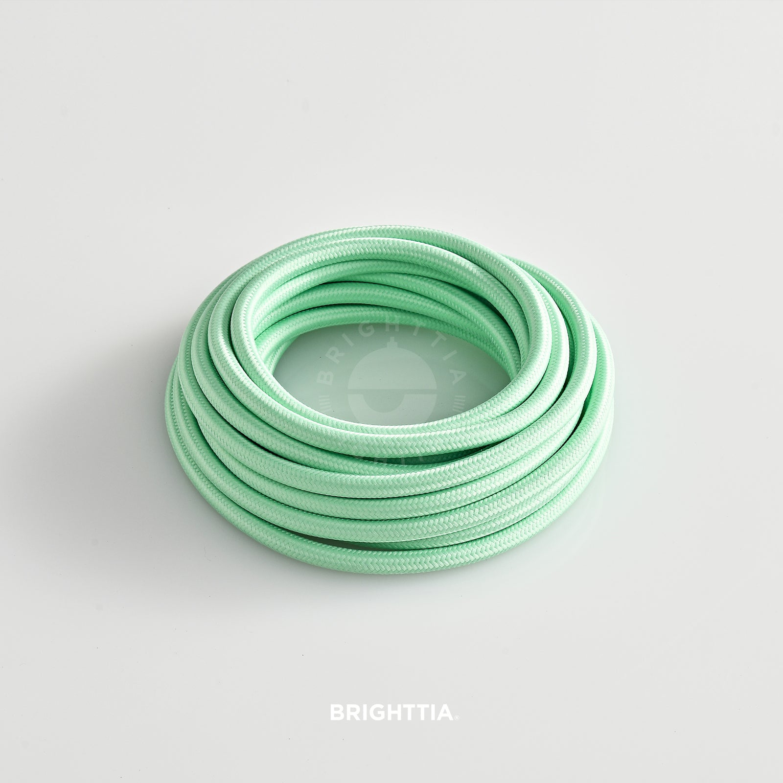 A roll of solid round mint green fabric cord 4.88m (16ft) on a white background
