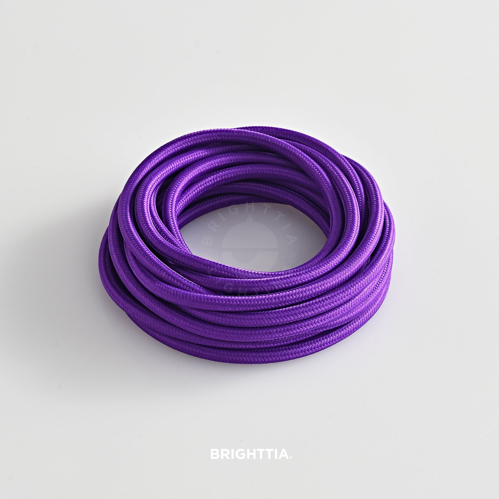 A roll of solid round purple fabric cord 4.88m (16ft) on a white background