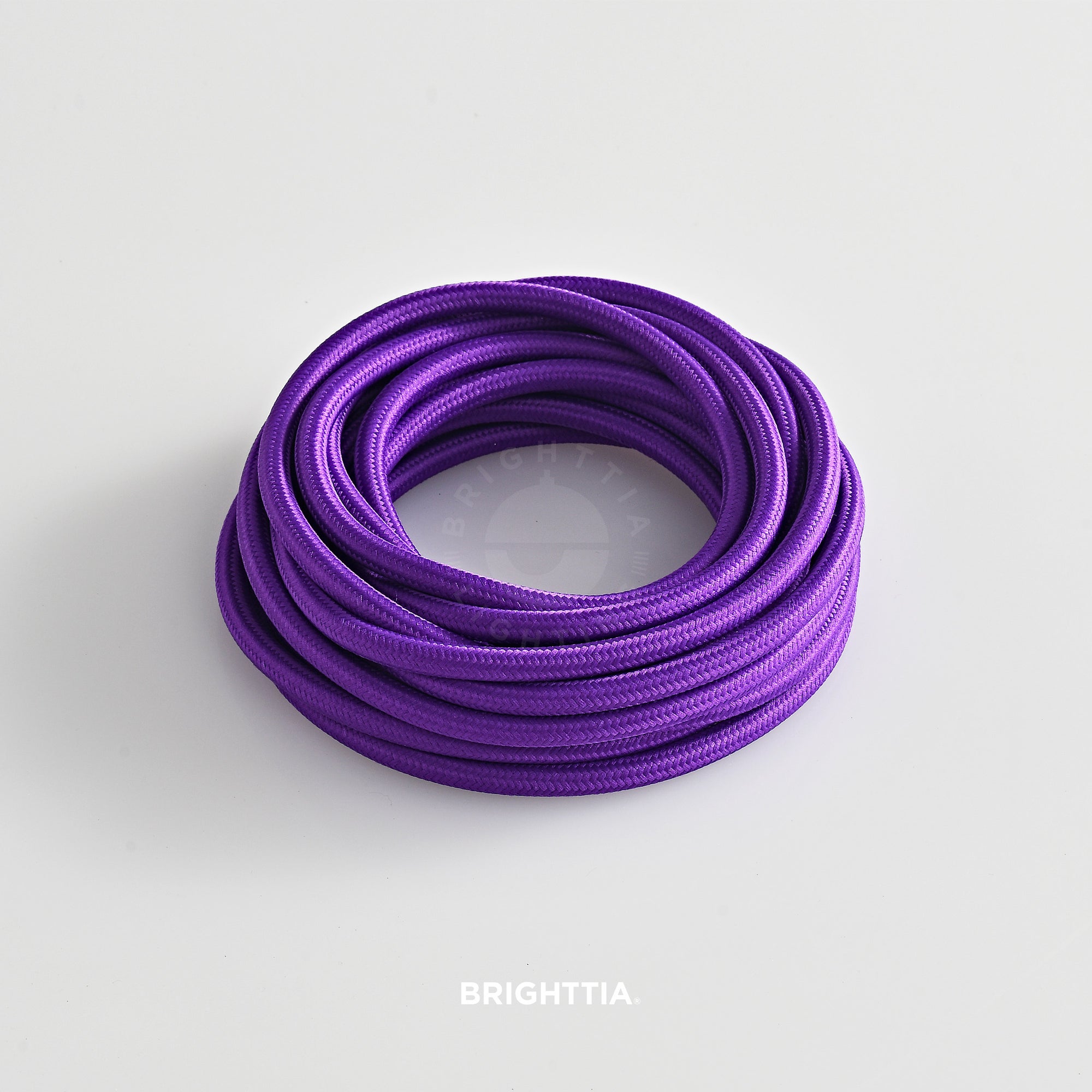 A roll of solid round purple fabric cord 4.88m (16ft) on a white background