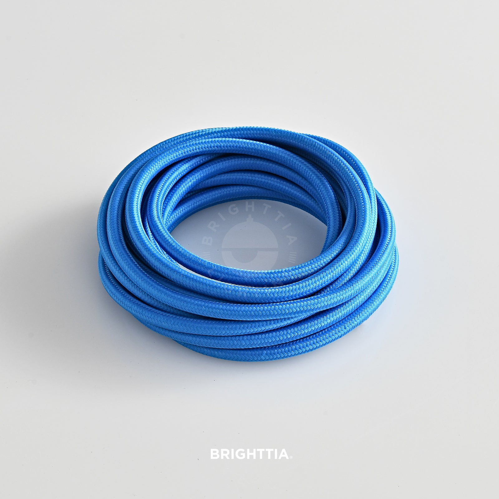 A roll of solid round electric blue fabric cord 4.88m (16ft) on a white background