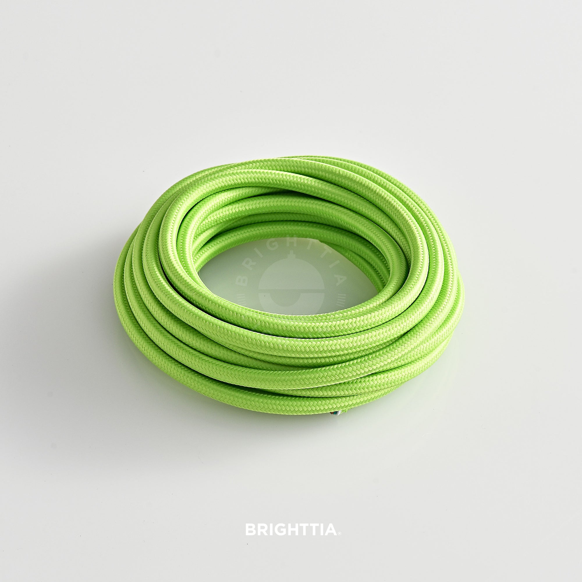 A roll of solid round lime green fabric cord 4.88m (16ft) on a white background