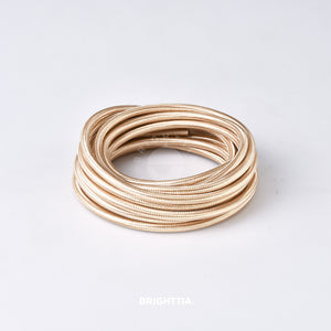 A roll of solid round gold fabric cord 4.88m (16ft) on a white background